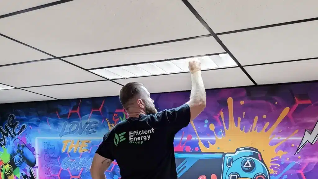 Efficient Energy Group installer fitting an LED panel in a Sydney office ceiling