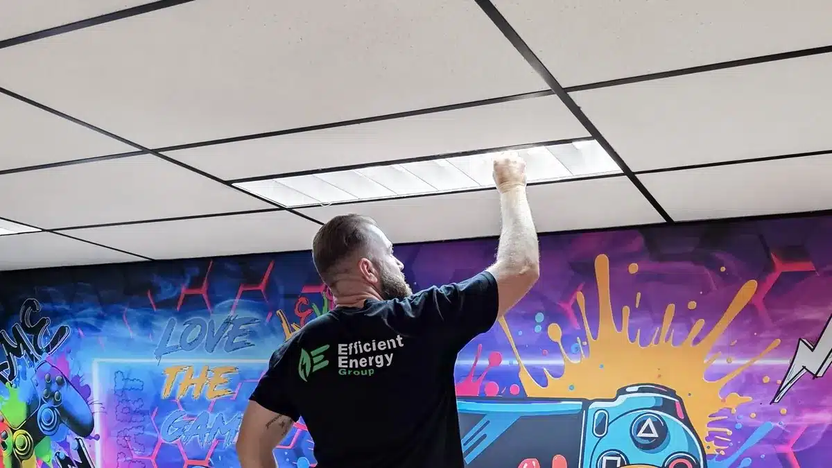 Efficient Energy Group installer fitting an LED panel in a Sydney office ceiling